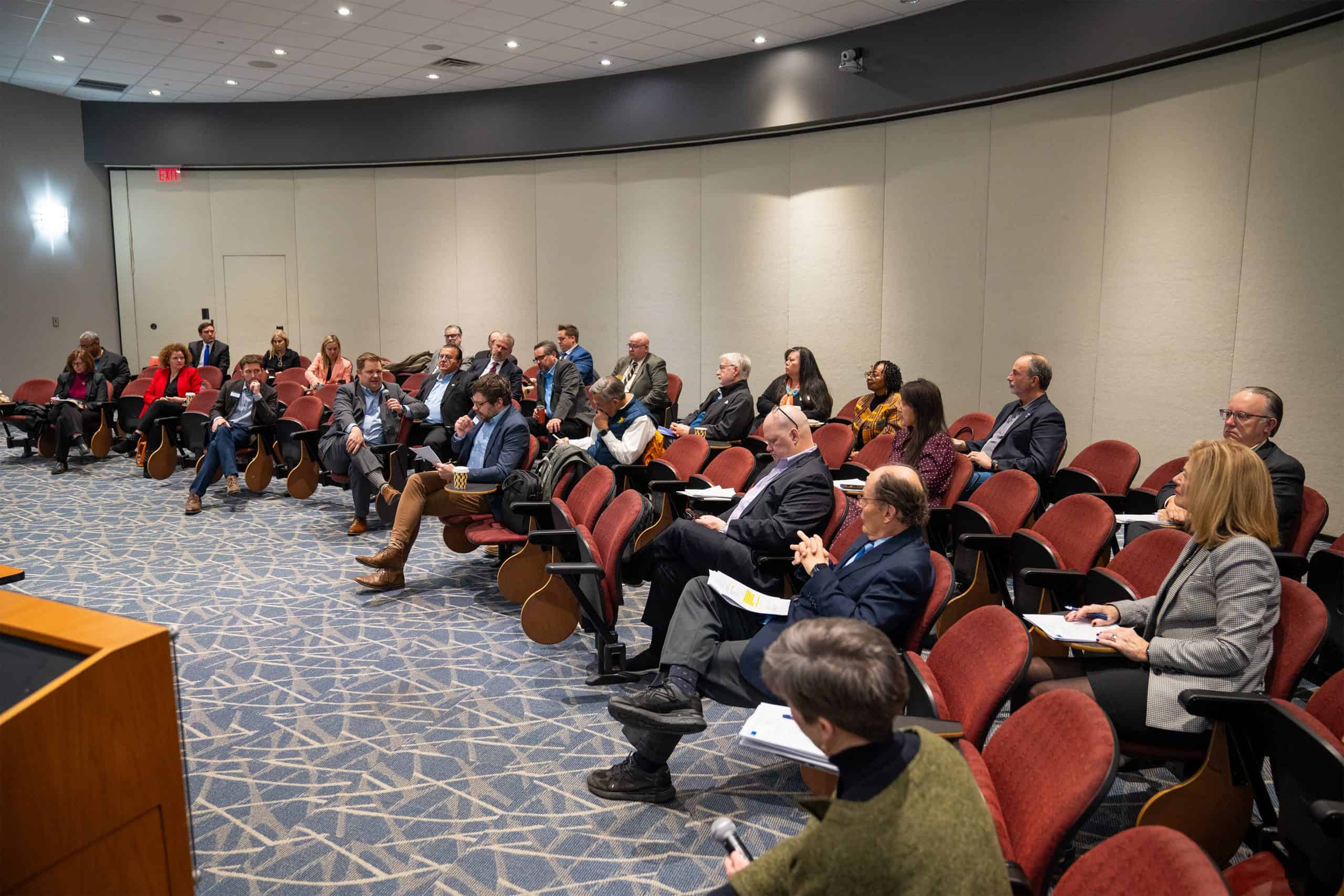 business people attending a conference sitting in chairs