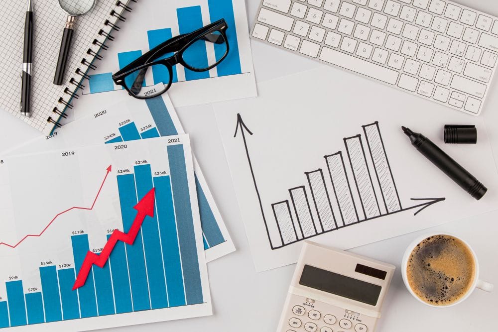 Top view of an office desk with a growth chart and glasses on the desk